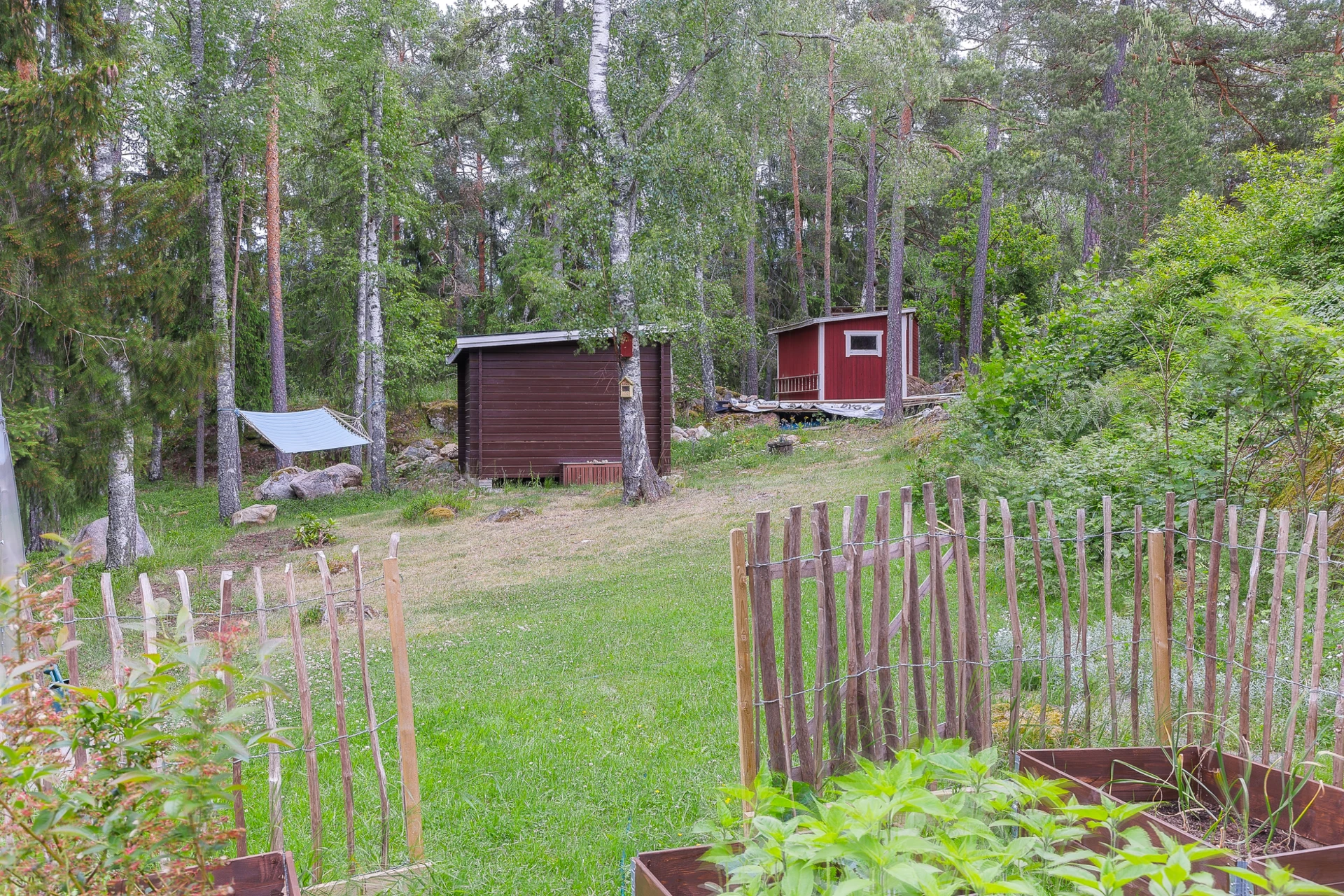 Odlingslott mot gäststuga och förråd