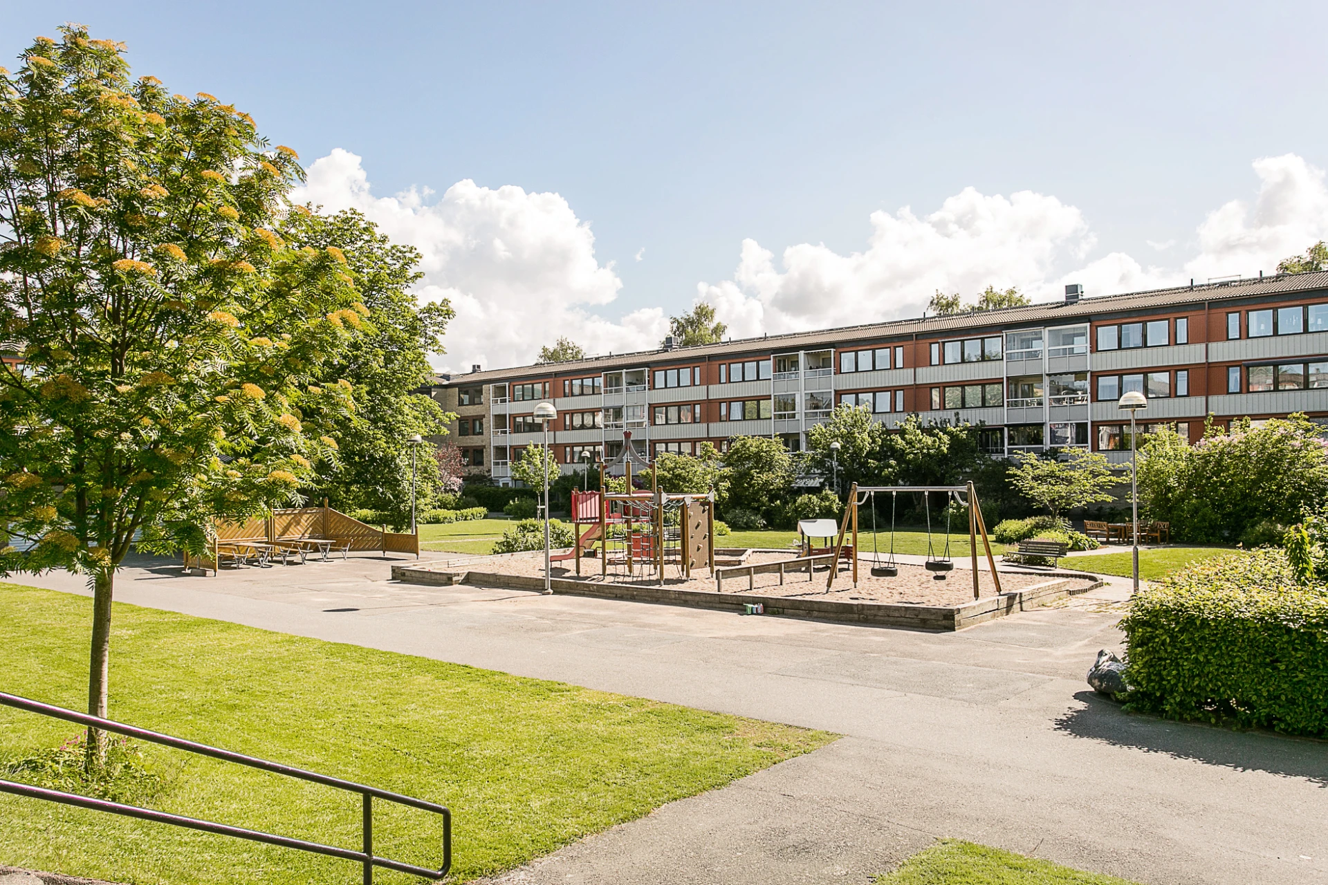Gemensam gård med lekplats, utemöbler och grill