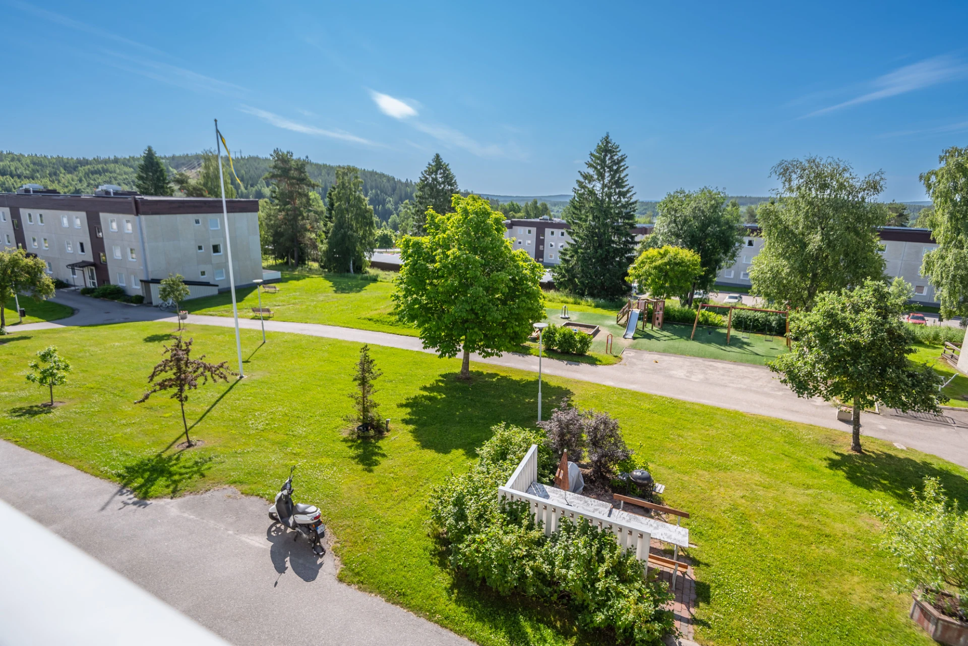 Del av utsikten från balkongen med grillplatsen och lekplatsen