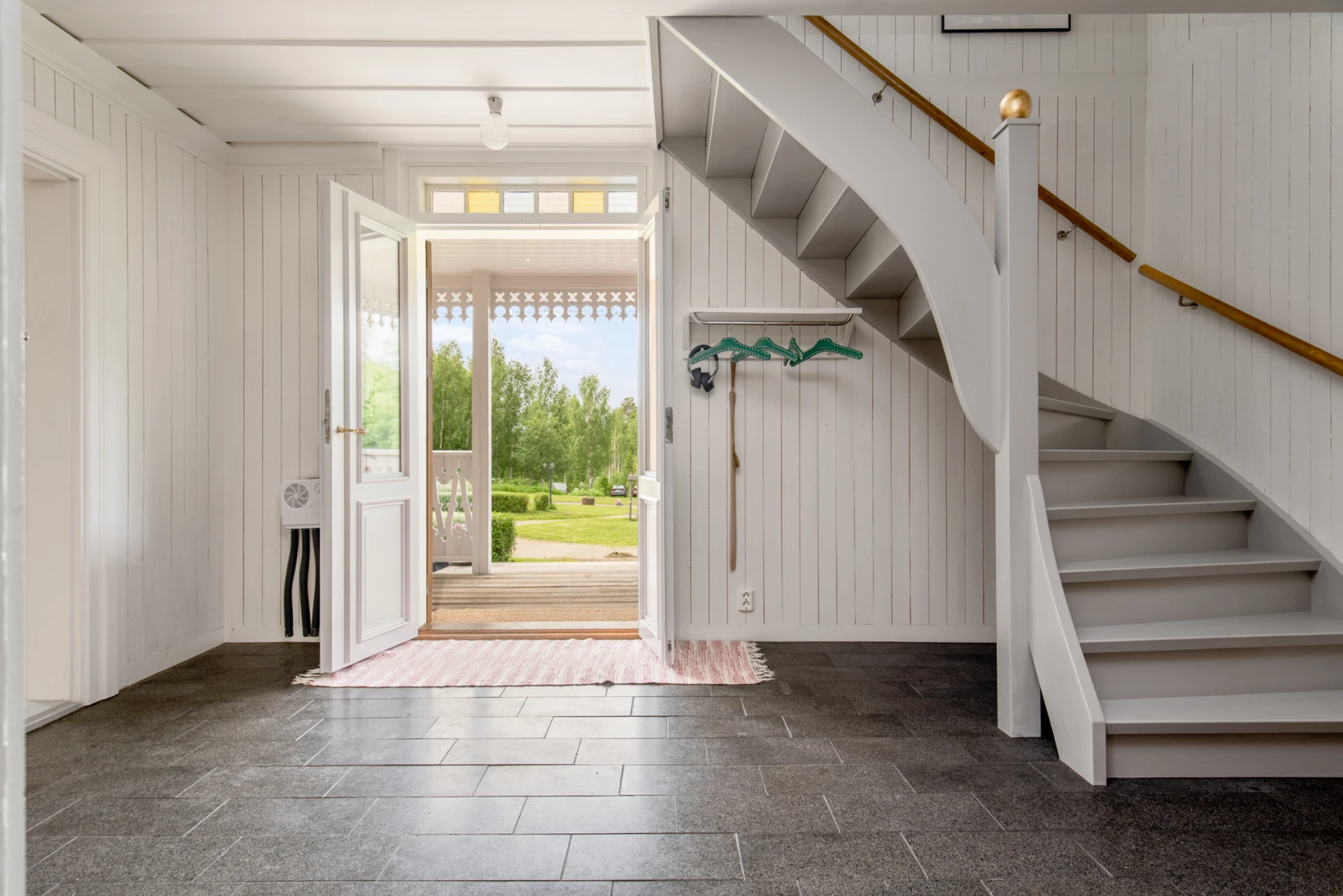 Välkomnande entréhall med trappan upp till övre plan