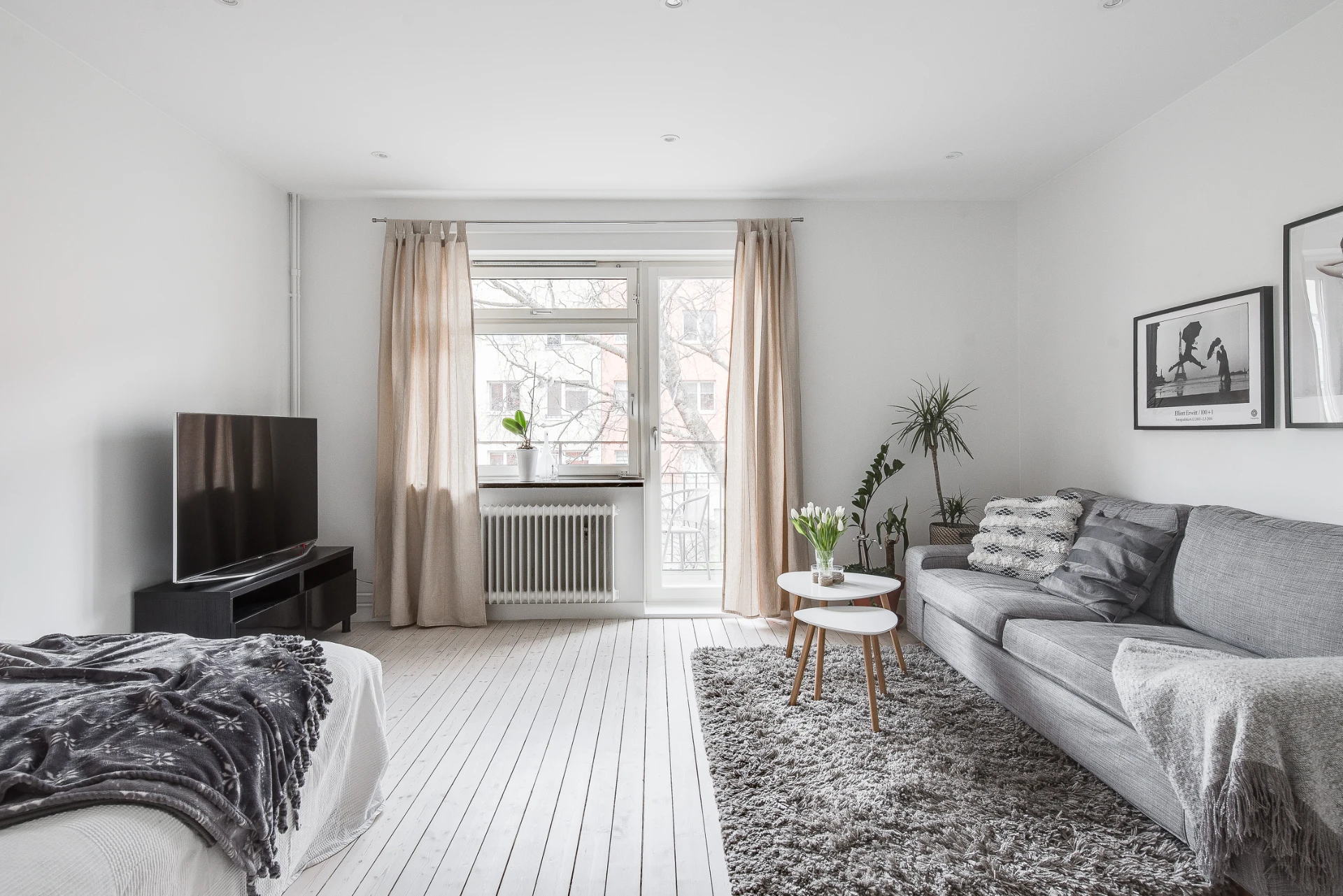 Ljust vardagsrum med plats för soffgrupp och säng